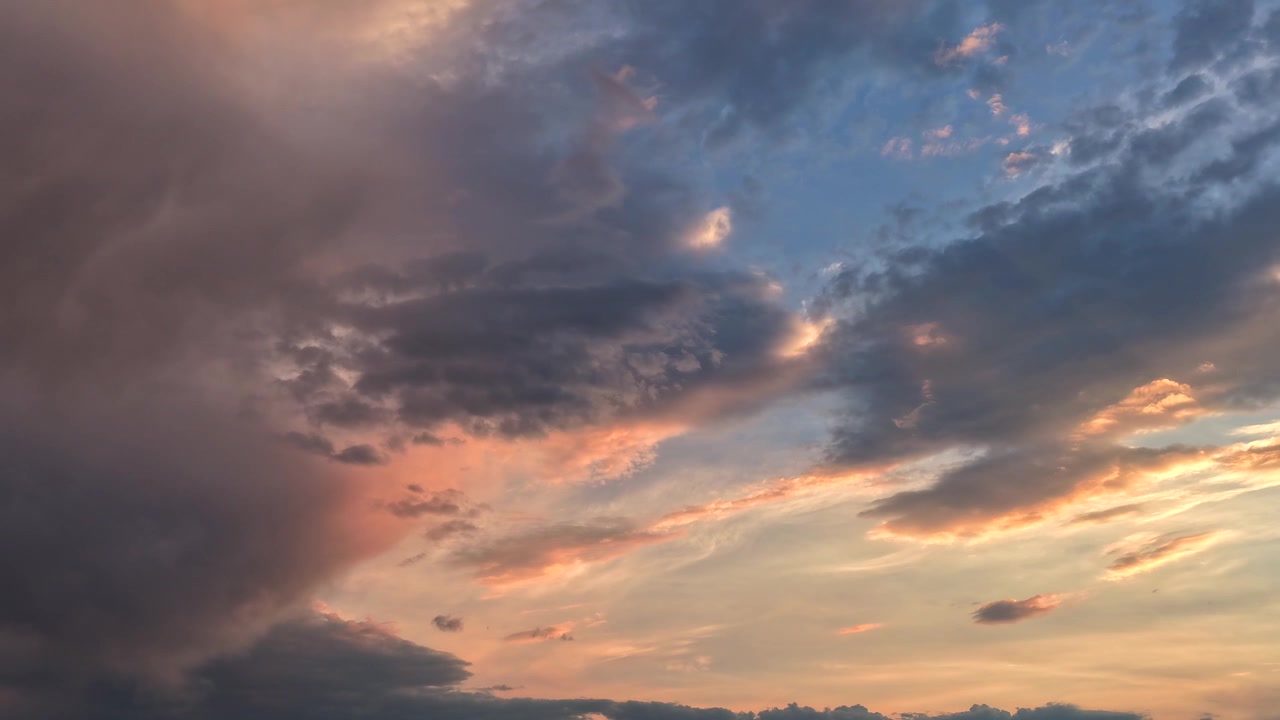 4K B-roll transition drone timelapse of a weather landscape. Captures a sunset sky where clouds are discolored by mixed fire smoke, showing shifting cloud layers and moving contrast at massive scale.