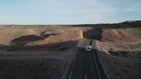 rv driving on road through rock formations in utah, usa