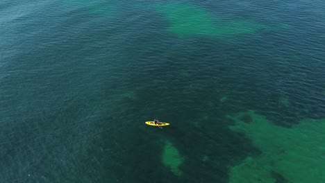 Aerial-view-of-kayak-fishing-at-seascape,-trolling-fishing-drone-view