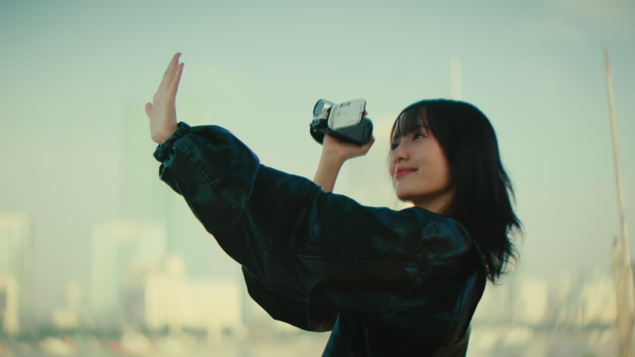 Young Woman Taking Selfie with Retro Video Camera in City