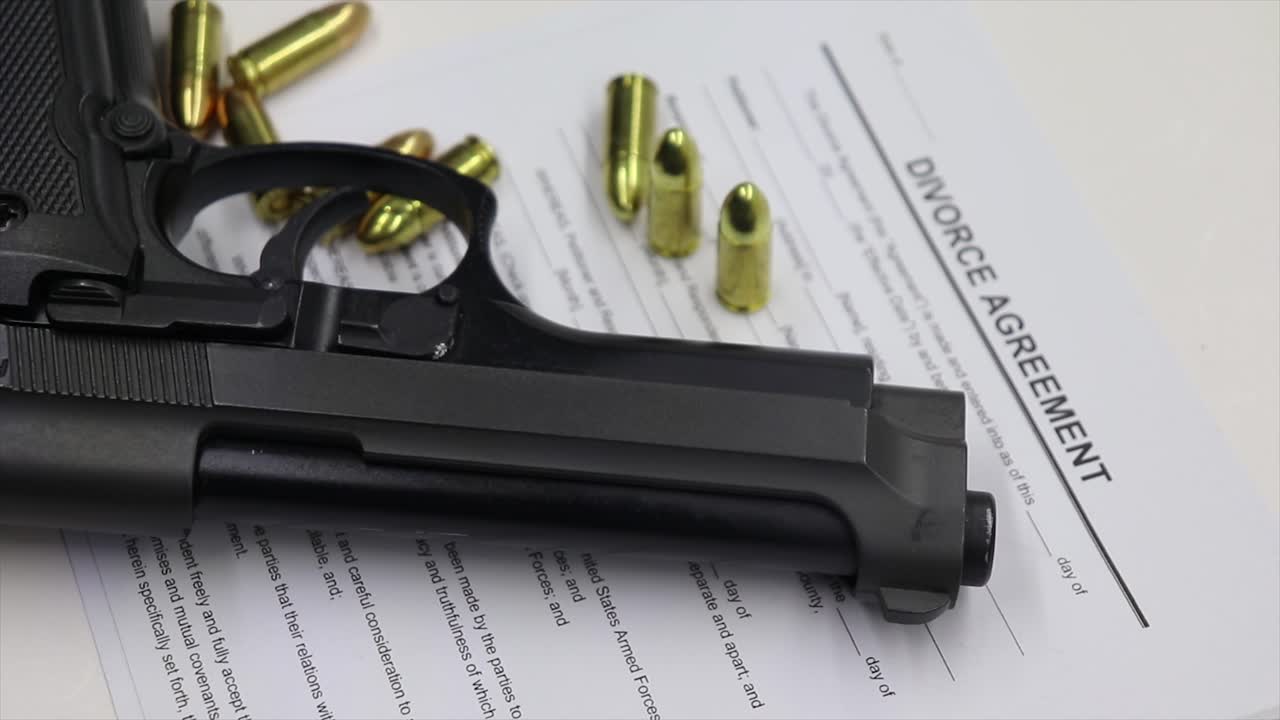 Firearm magazine and live ammunition bullets on a table with  divorce papers