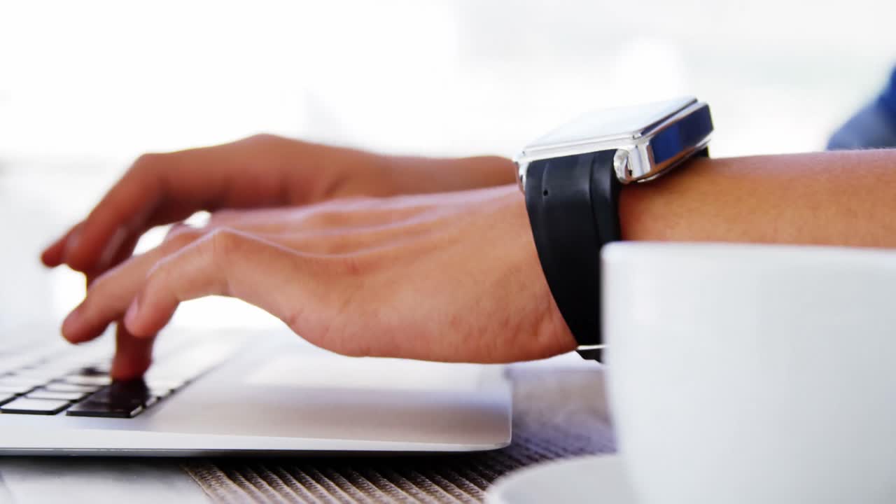 man with coffee cup using laptop