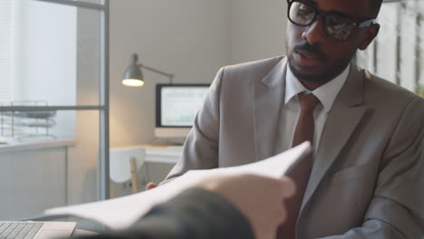 black businessman signing contract and shaking hands with partner