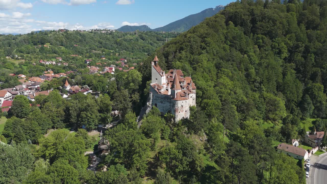 Fluido approccio orbitante che mette in risalto l'architettura del Castello di Bran e il pittoresco paesaggio transilvano