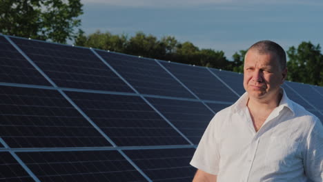 home power plant owner walks along row of solar panels
