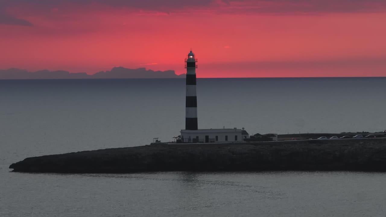 Drone panoramic at Sunset, lighting Cap d’Artrutx Lighthouse fire landscape, skyline of Cala en Bosch, Coastline
