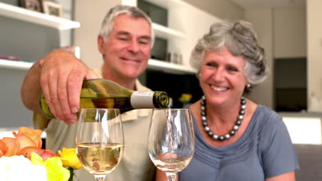 Hombre-Sonriente-Sirviendo-Una-Copa-De-Vino-Blanco-Para-Su-Esposa