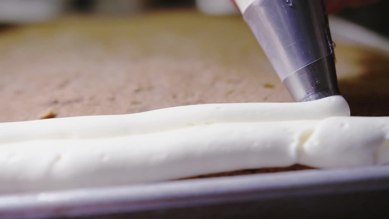 pastelero vertiendo glaseado o glaseado sobre un pastel en capas