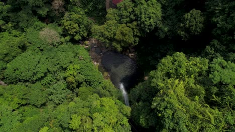 katibawasan waterfall flows into rock pool below, top down aerial
