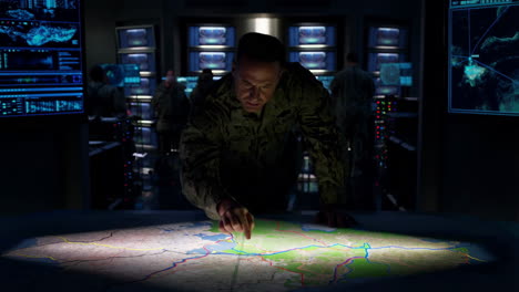 military personnel in a command center analyzing a map