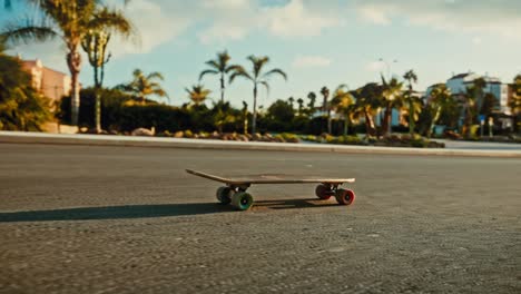 Verlassenes-Skateboard-Rutscht-Sonnige-Tropische-Straße-Hinunter