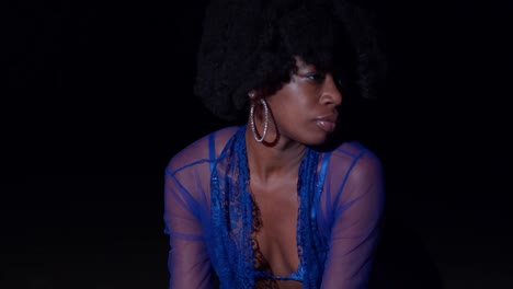 primer plano facial de una chica negra en lencería en la playa con un peinado afro