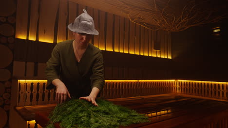 woman preparing a sauna with fir branches