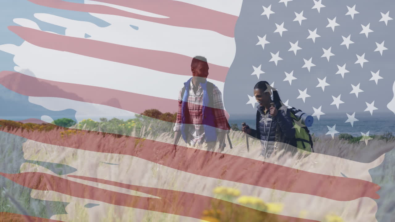 Animation of american flag over smiling diverse couple hiking in mountains