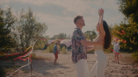 Young-man-and-woman-dancing-bachata-intimately-at-beach