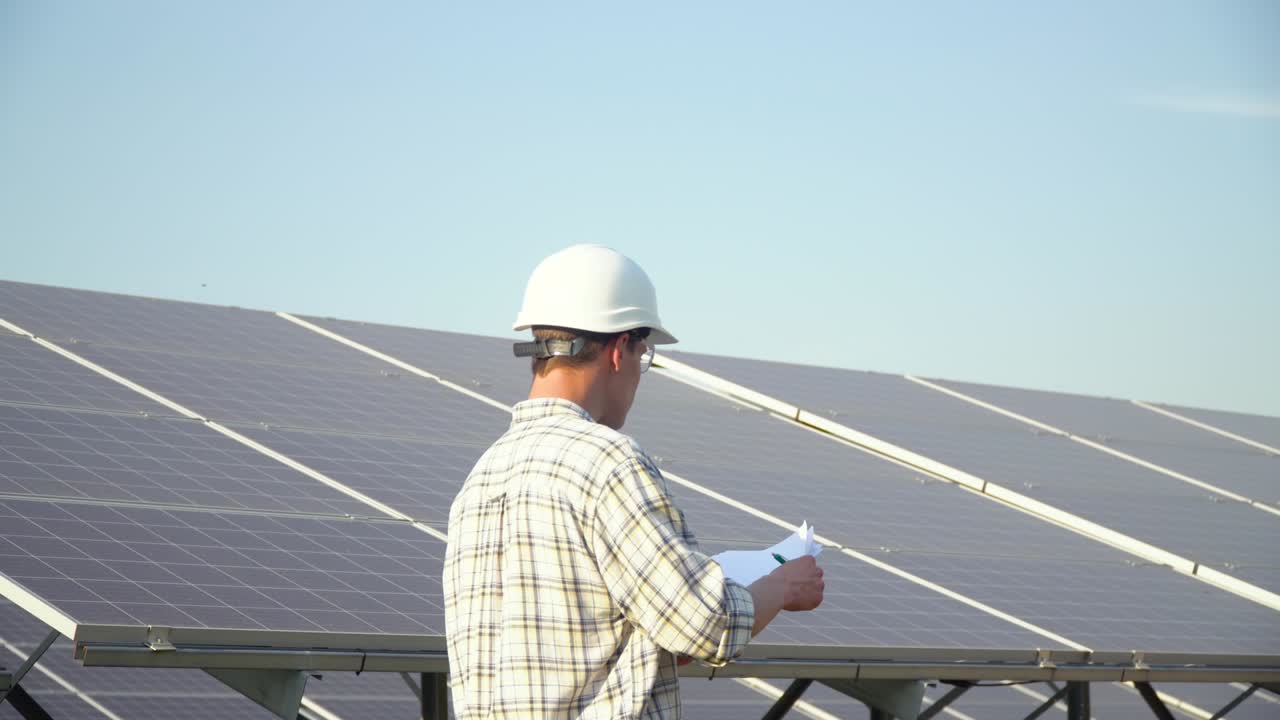 Engineer checks solar panels productivity. Photovoltaic panel