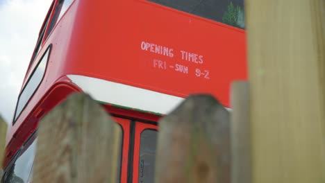 iconic red english bus was transformed into a bar restaurant opening times written on the bus