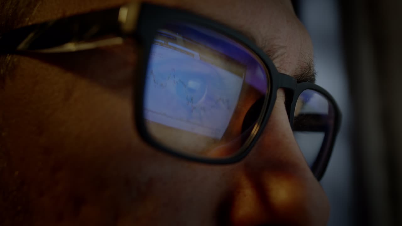 el hombre con gafas para la visión está enfocado en mirar un monitor de computadora.