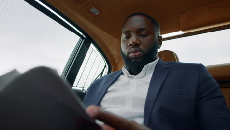 bsinessman reading documents at car. man sitting with papers at remote workplace