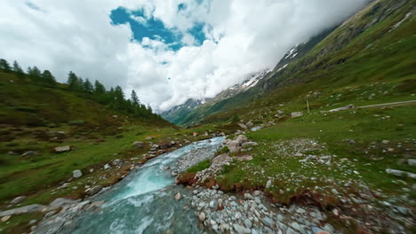 flowing mountain stream in a lush valley near cervinia under a vibrant sky