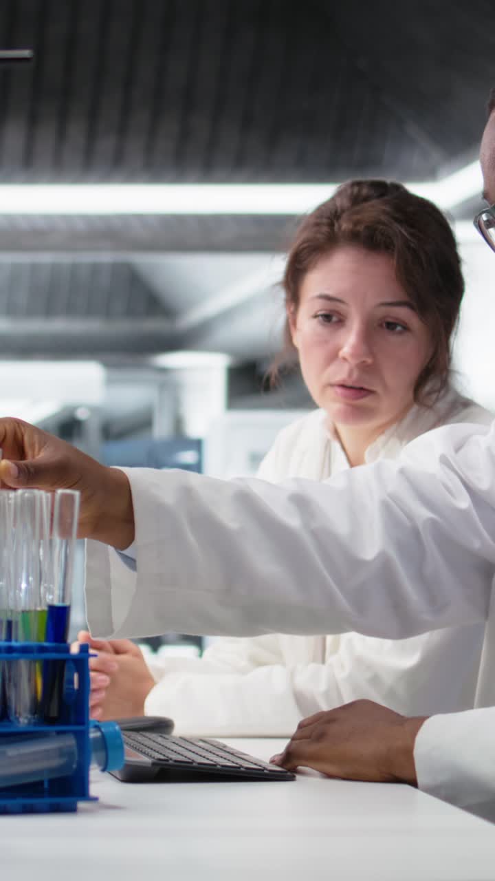 Vertical video Team of analytical chemists work together, using laboratory solutions