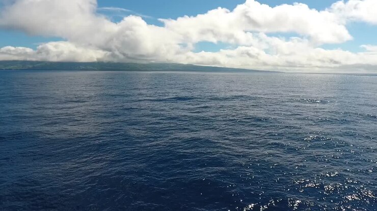 Breve volo sopra l'oceano con un'isola in lontananza