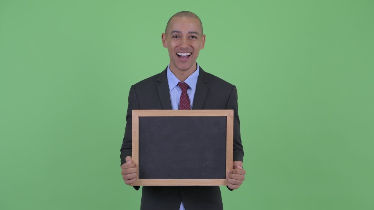 feliz guapo calvo hombre de negocios multiétnico con pizarra