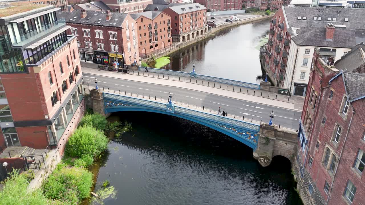 Aerial drone footage of a Victorian bridge over River Aire, historic Leeds city center, daylight