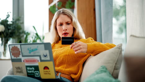 worried woman with credit card using laptop