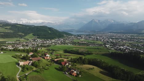 Aerial-of-farms-with-a-small-town-and-mountains-in-the-background