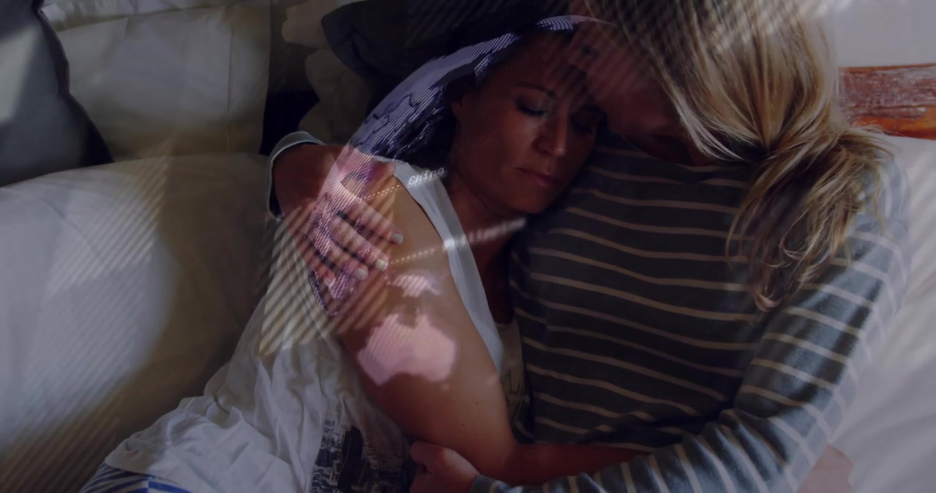 Donna che si appoggia al partner per rassicurazione sul divano in un video sulla salute, con un'icona a cuore fluttuante