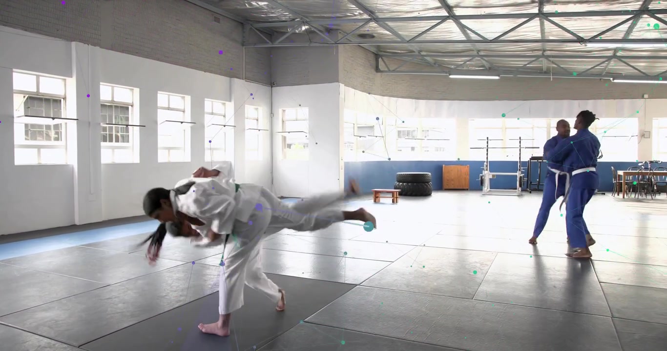 Afferrando i judogi, un duo femminile e partner maschili eseguono lanci di judo e spazzate alternate per l'allenamento.