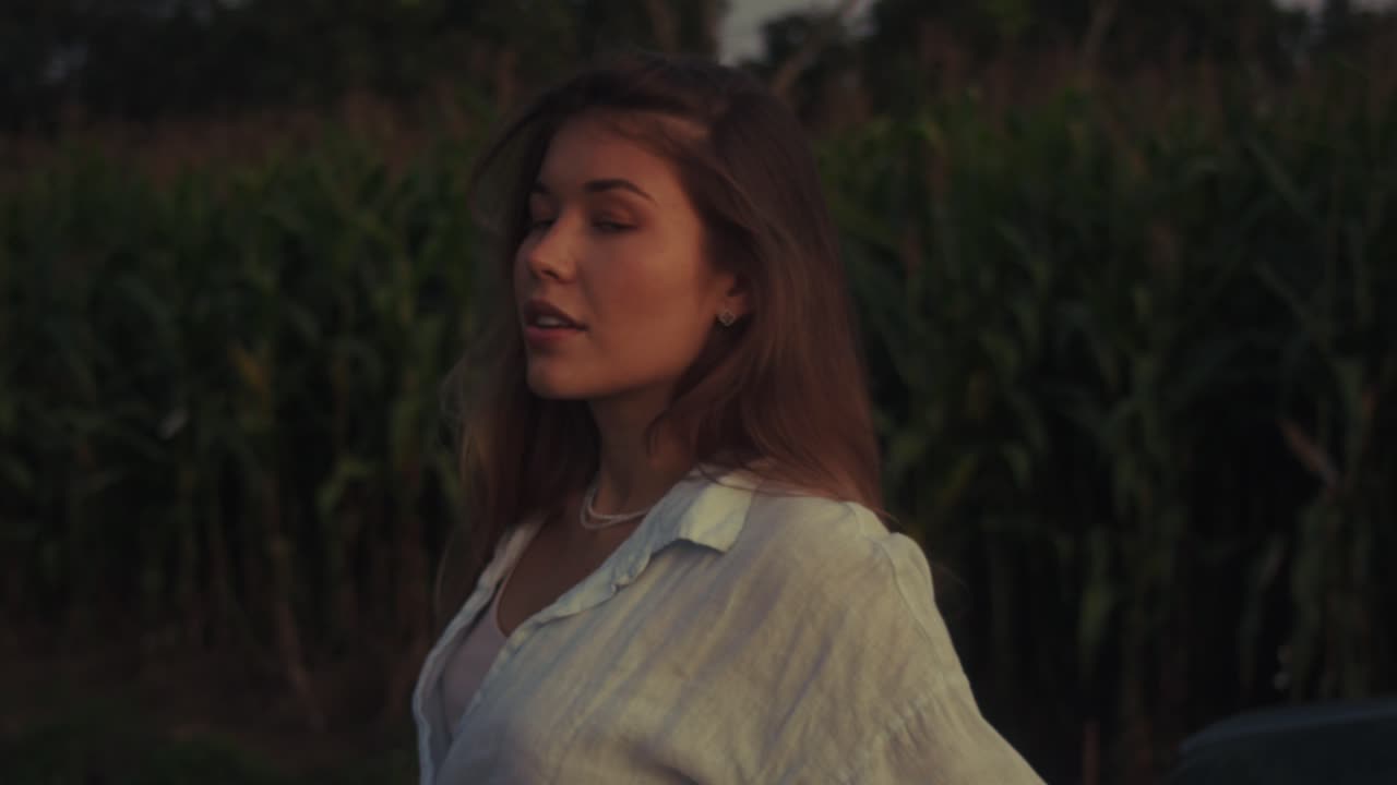 Woman in a corn field at sunset