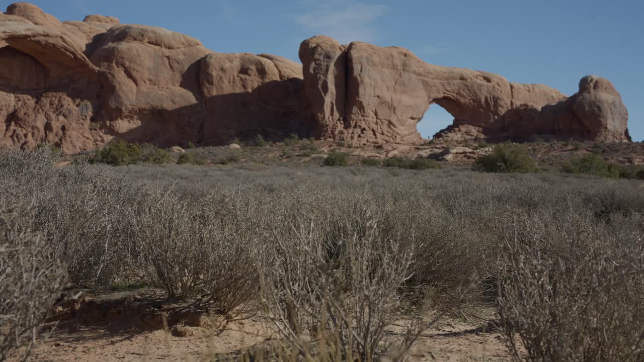 Travelling cinématographique de North Window Arch dans le parc national des Arches, dans l’Utah. Arche de roche de grès emblématique située dans un paysage désertique pittoresque présentant la géologie naturelle et les paysages de parcs nationaux.
