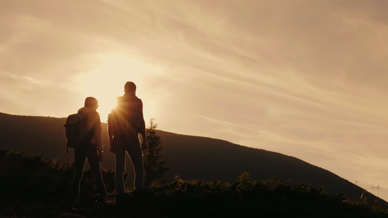 등 뒤에서 배낭을 메고 서로를 때리는 등산가 한 쌍의 정상과 리더십에 대한 성공