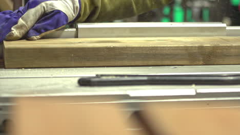 carpenter cutting wooden plank with table circular saw