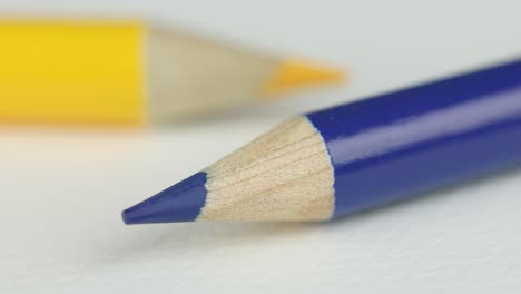 extreme close of sharp blue pencil with shallow yellow pencil in background