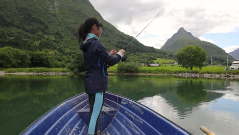 Frau-Auf-Dem-Boot-Fängt-Einen-Fisch-Beim-Spinnen-In-Norwegen.