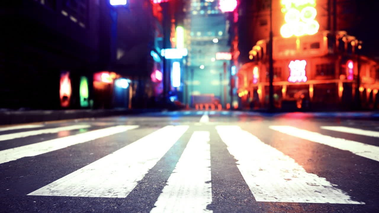 City street at night featuring bright neon lights and empty crosswalk
