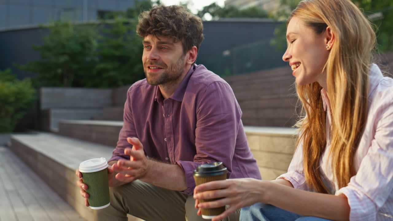 도시 공원에서 사랑의 커플 대화 데이트 클로즈업. 수염이 있는 남자가 웃는 소녀와 대화를 나누고