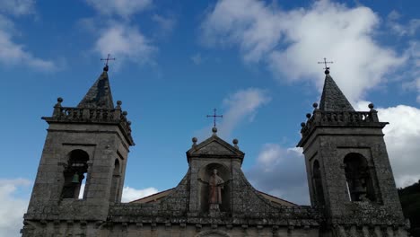 bell towers and saint sculpture on a rooftop, santo estevo monastery, spain