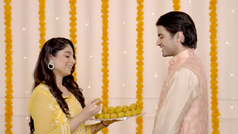 pareja india comiendo dulces en diwali