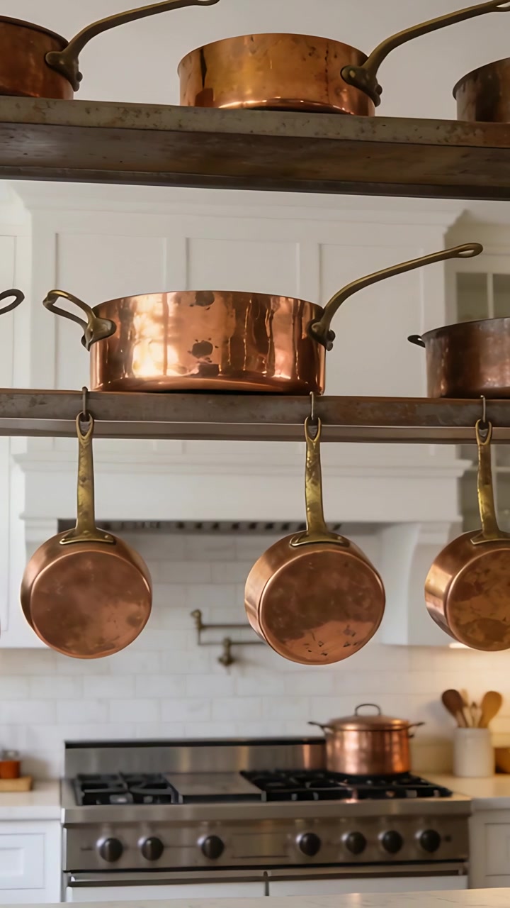 Vertical video: Panning camera prompted by frame shift at kitchen range, revealing copper cookware