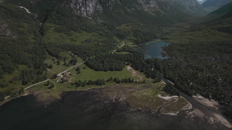 majestic mountains and blue lake in innerdalen norway - aerial pull out shot