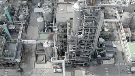 aerial top-down view of intricate industrial piping, tanks, and tower structures at large facility, veille-saint-girons, france