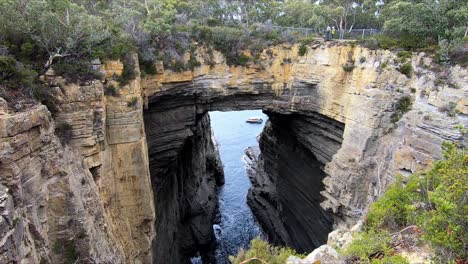 arco de tasman con barco turístico visible navegando más allá del arco