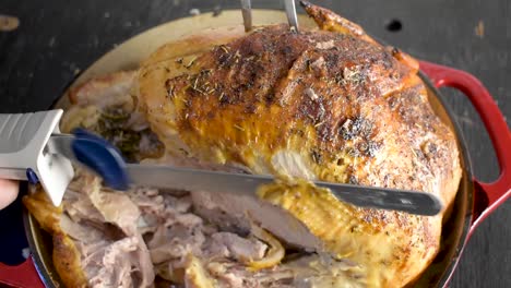 carving baked whole turkey with herbs with electric knife