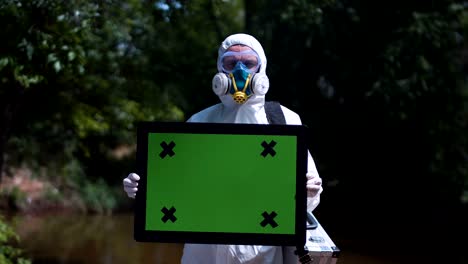 man in protective suit holding green screen