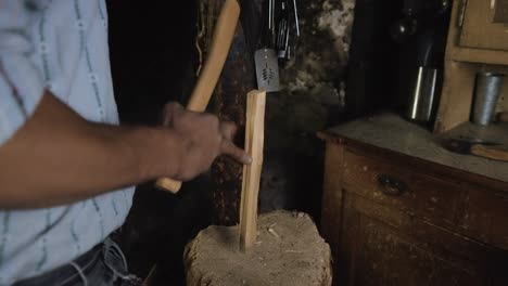 cámara lenta, hombre irreconocible cortando, partiendo leña por la mitad con hacha