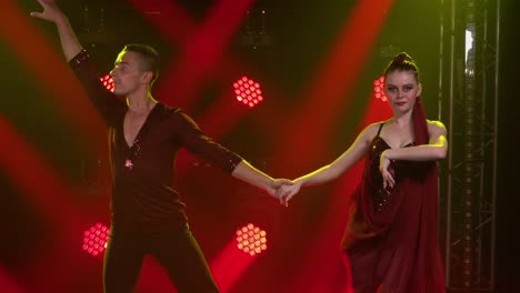 dynamic couple dance performance with dramatic red lighting